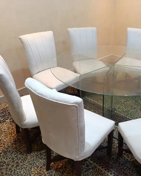 كراسي بيضاء حول طاولة زجاجية