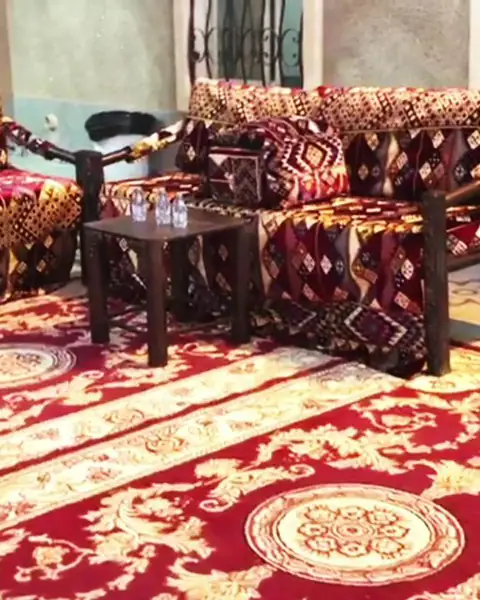جلسة بفرش وسجاد أحمر وطاولات صغيرة