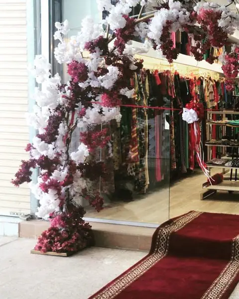قوس من الزهور البيضاء والبنفسجية بجانب سجادة حمراء