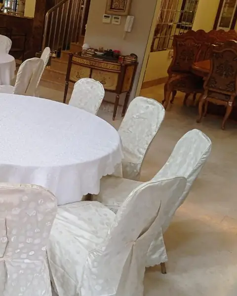 كراسي مغطّاة بالأبيض حول طاولة دائرية