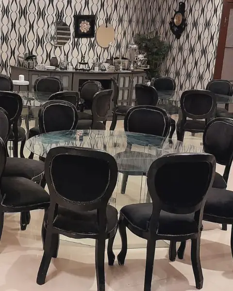 كراسي سوداء حول طاولة زجاجية دائرية