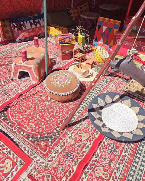 سجاد أحمر تراثي وصينية ووسائد في خيمة