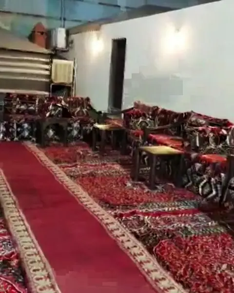 جلسة تراثية بأرائك حمراء وسجاد مزخرف