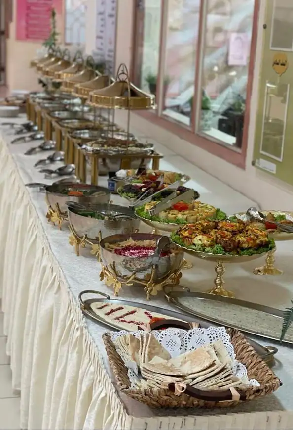 طاولة بوفيه طويلة بأواني تقديم ذهبية وأطباق سلطة