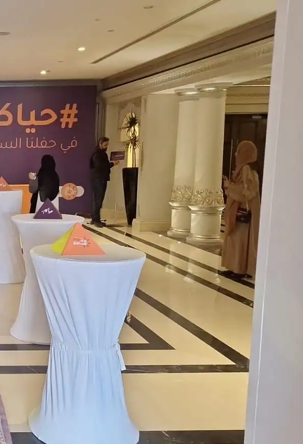 طاولات كوكتيل عالية مكسوة بأقمشة بيضاء في ردهة فندق