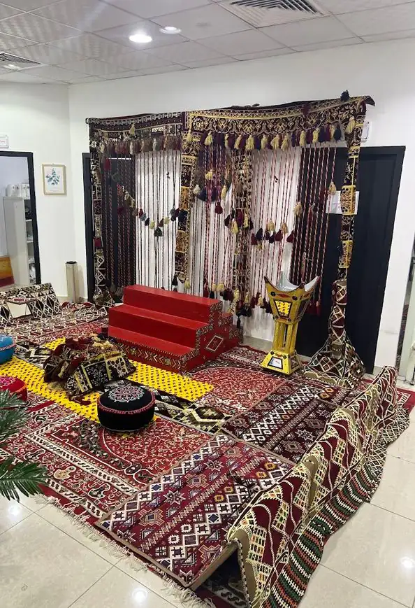 ركن تراثي بسجاد ومفارش سدو ودرج أحمر ودلة نحاسية