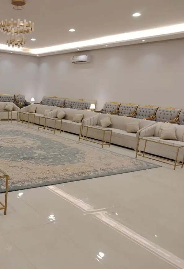 مجلس واسع بأرائك كريمية حول سجادة في الوسط