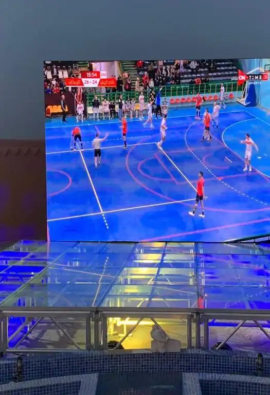 شاشة عرض كبيرة فوق منصة مرفوعة ومضاءة في فناء