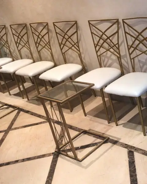 كراسي بإطار ذهبي ومقاعد بيضاء مصفوفة في صف واحد