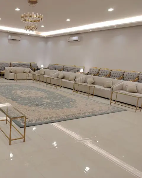 مجلس واسع بأرائك كريمية حول سجادة في الوسط