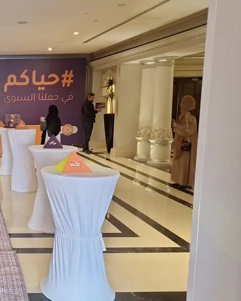 طاولات كوكتيل عالية مكسوة بأقمشة بيضاء في ردهة فندق
