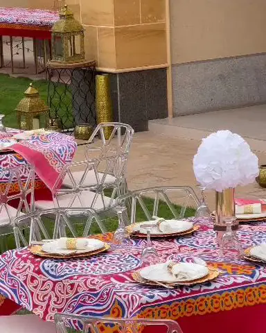 طاولات مجهزة بمفارش ملونة مزخرفة على العشب