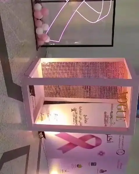 طاولة مضاءة بإضاءة وردية خلف إطار نيون على شكل شريط