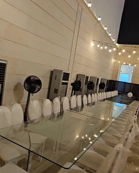مبردات هواء واقفة على امتداد طاولة زجاجية طويلة في قاعة