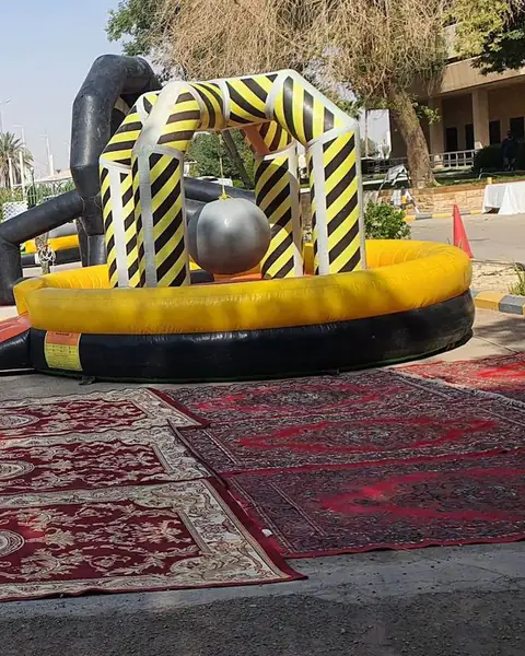 لعبة قابلة للنفخ للأطفال فوق سجاد أحمر في ساحة مفتوحة